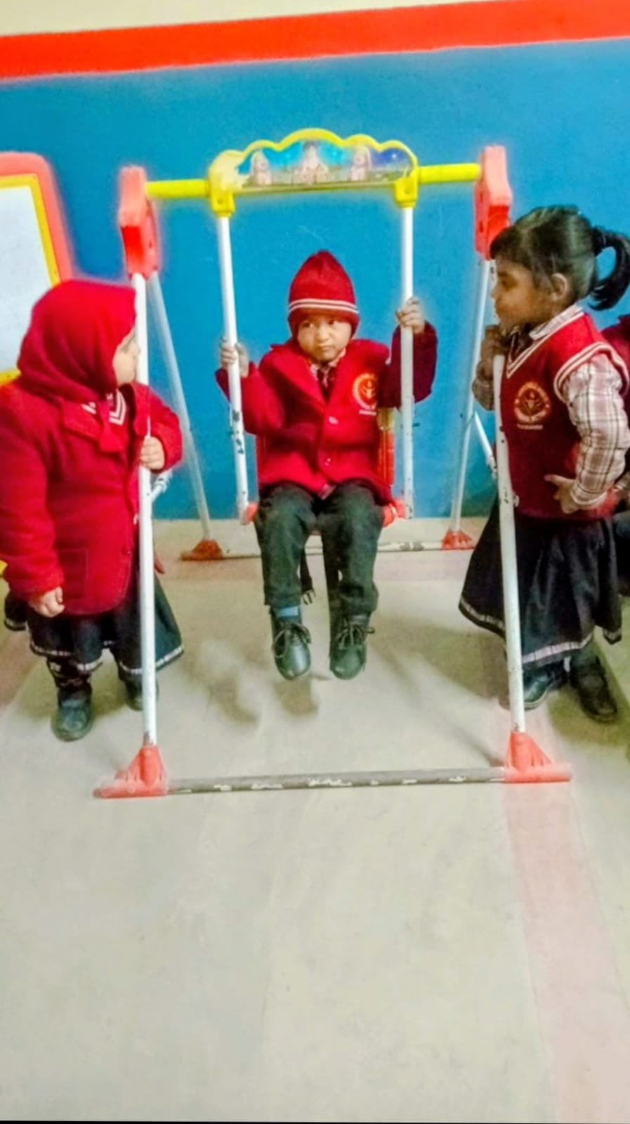 Toddlers playing on indoor swing